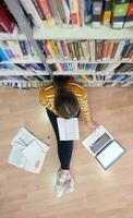 the student uses a notebook and a school library photo