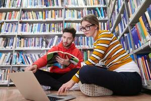 los estudiantes usan un cuaderno, una computadora portátil y una biblioteca escolar foto