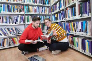 los estudiantes usan un cuaderno, una computadora portátil y una biblioteca escolar foto