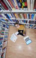 the student uses a notebook and a school library photo