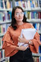 the student uses a notebook and a school library photo