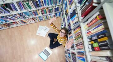 the student uses a notebook and a school library photo