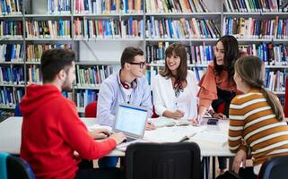 grupo de estudiantes trabajando juntos en un proyecto escolar en una tableta en una universidad moderna foto