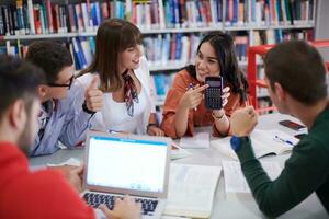 students group working on school project together on tablet computer at modern university photo