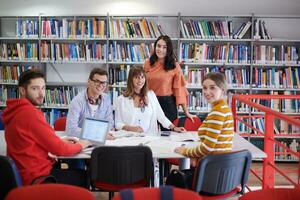 grupo de estudiantes trabajando juntos en un proyecto escolar en una tableta en una universidad moderna foto