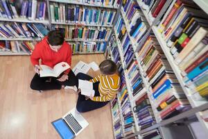 los estudiantes usan un cuaderno, una computadora portátil y una biblioteca escolar foto