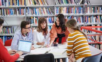 grupo de estudiantes trabajando juntos en un proyecto escolar en una tableta en una universidad moderna foto