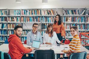 grupo de estudiantes trabajando juntos en un proyecto escolar en una tableta en una universidad moderna foto