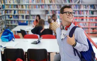 el estudiante usa un cuaderno, una computadora portátil y una biblioteca escolar foto