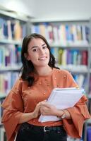 the student uses a notebook and a school library photo