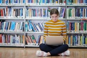 the student uses a notebook and a school library photo