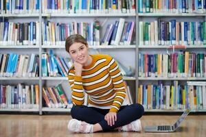 the student uses a notebook and a school library photo