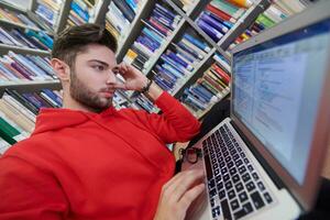 the students uses a notebook, laptop and a school library photo