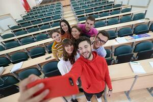 grupo de adolescentes multiétnicos tomando un selfie en la escuela foto