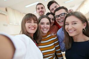 grupo de adolescentes multiétnicos tomando un selfie en la escuela foto