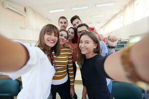 grupo de adolescentes multiétnicos tomando un selfie en la escuela foto