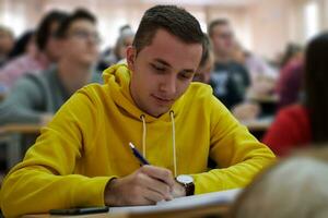 estudiante tomando notas mientras estudia en la escuela secundaria foto