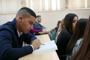 estudiante tomando notas mientras estudia en la escuela secundaria foto