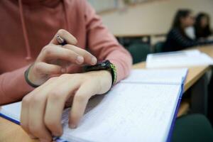 the student uses a smartwatch in math class photo