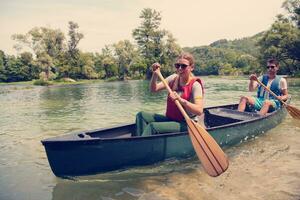 couple of explorers conoining on wild river photo