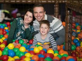 young parents with kids in a children's playroom photo