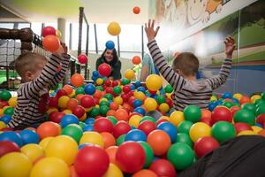 madre joven con sus hijos en una sala de juegos para niños foto