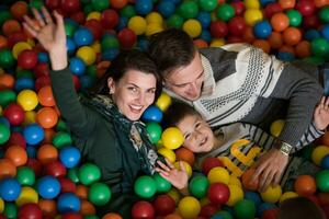 padres jóvenes con hijos en una sala de juegos para niños foto