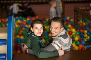 padres jóvenes con hijos en una sala de juegos para niños foto