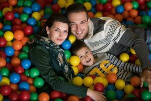 padres jóvenes con hijos en una sala de juegos para niños foto