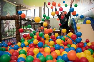 madre joven con sus hijos en una sala de juegos para niños foto