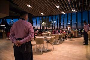 waiter standing with hands behind his back photo