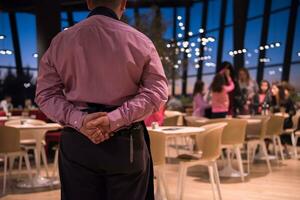 waiter standing with hands behind his back photo