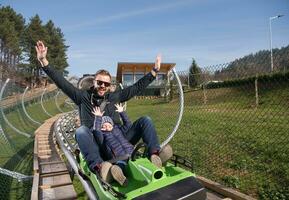 father and son enjoys driving on alpine coaster photo