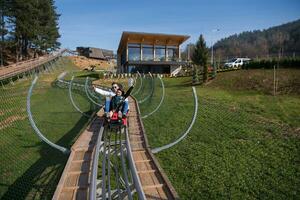 couple enjoys driving on alpine coaster photo