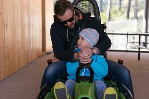 padre e hijo disfrutan conduciendo en montaña rusa alpina foto