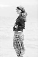 hermosa mujer joven en la playa con bufanda foto