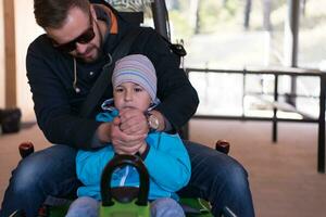 father and son enjoys driving on alpine coaster photo