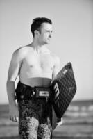 Portrait of a young  kitsurf  man at beach on sunset photo