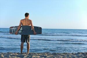 retrato, de, un, joven, kitsurf, hombre, en, playa, en, ocaso foto