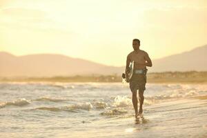 Portrait of a young  kitsurf  man at beach on sunset photo