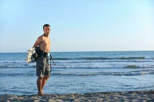 Portrait of a young  kitsurf  man at beach on sunset photo