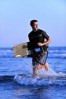 Portrait of a young  kitsurf  man at beach on sunset photo