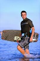 Portrait of a young  kitsurf  man at beach on sunset photo