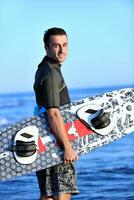 Portrait of a young  kitsurf  man at beach on sunset photo