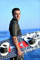 Portrait of a young  kitsurf  man at beach on sunset photo