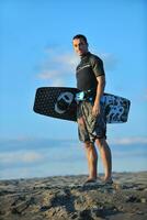 Portrait of a young  kitsurf  man at beach on sunset photo