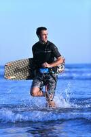Portrait of a young  kitsurf  man at beach on sunset photo