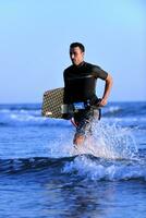 Portrait of a young  kitsurf  man at beach on sunset photo