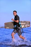 Portrait of a young  kitsurf  man at beach on sunset photo