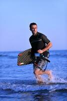 retrato, de, un, joven, kitsurf, hombre, en, playa, en, ocaso foto